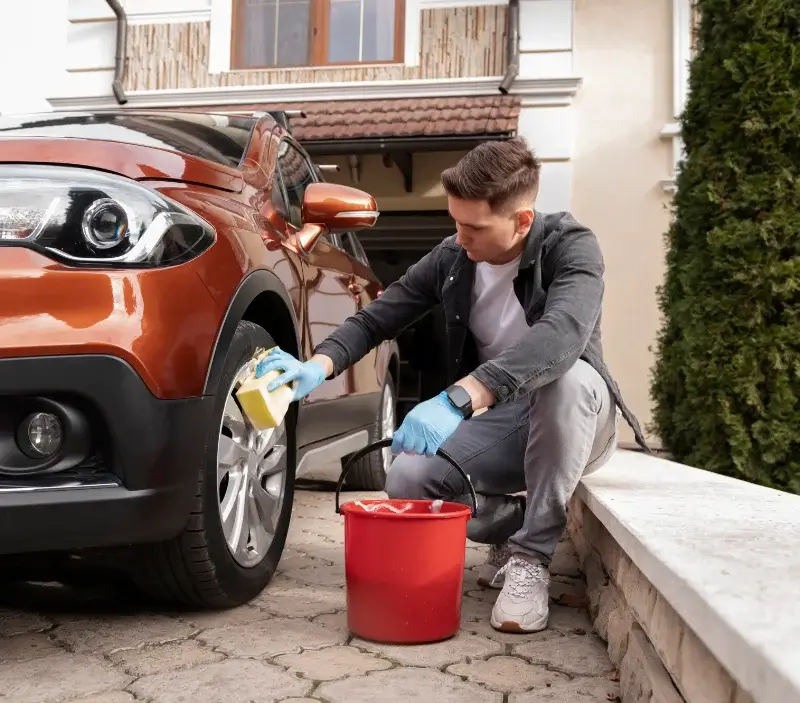 Lavage auto à domicile Ainay-le-Château : professionnel intervenant sur un véhicule